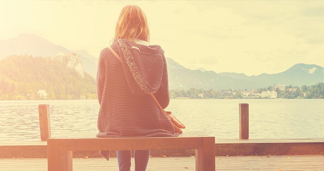 reflective person sitting on a bench